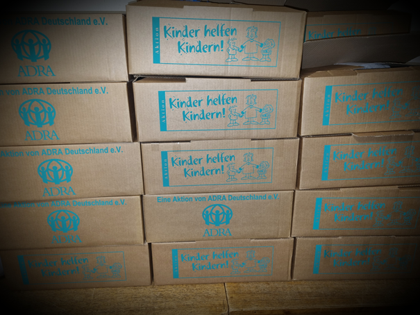 Kartons mit weihnachtlichen Überraschungen gefüllt für Kinder in Not